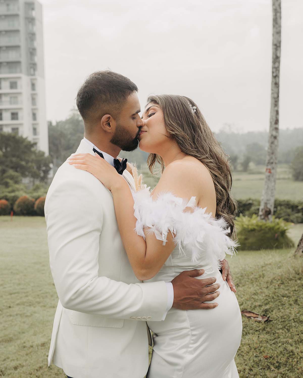 Romantic outdoor wedding kiss portrait in western bridal attire.